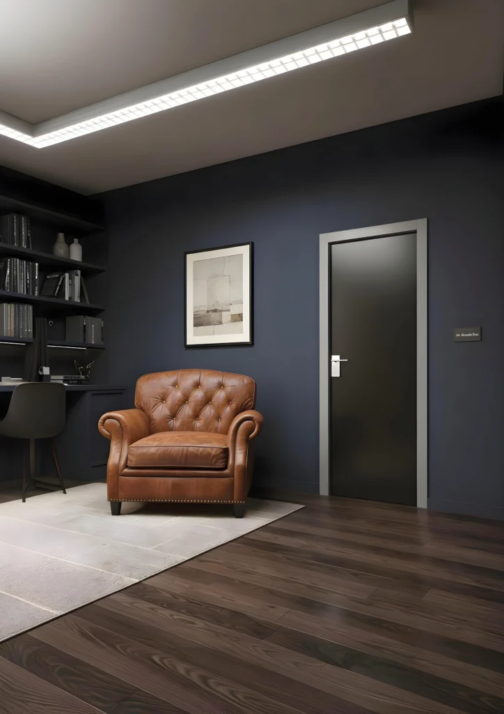 Porta della collezione Cristal con telaio laccato Soft Grigio e vetro bifacciale nero, inserita all'interno di uno studio sui toni del blu, nero e marrone.